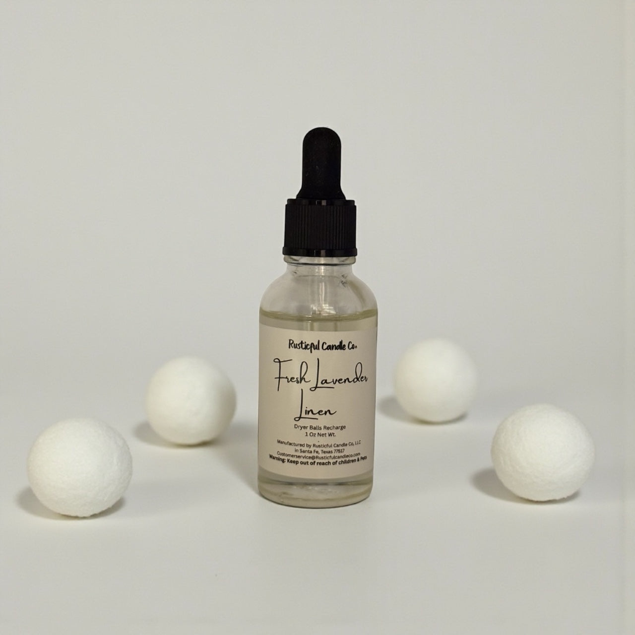 Bottle of Fresh Lavender Linen diffuser with cotton balls on a light gray background