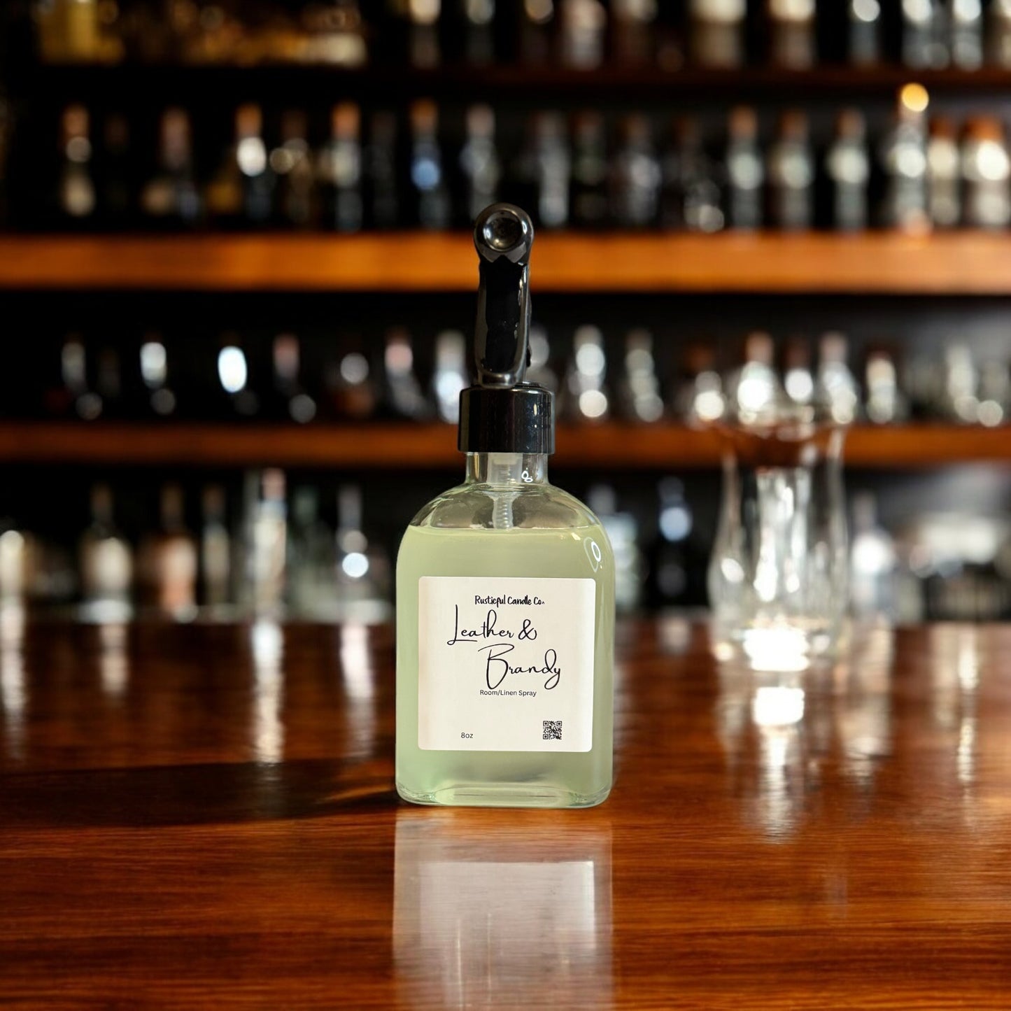 Bottle of 'Leather & Brandy' candle on a bar counter with blurred bottles in the background
