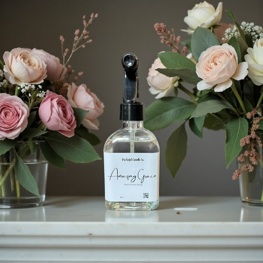 Bottle of 'Amoury Grace' with two flower arrangements in the background