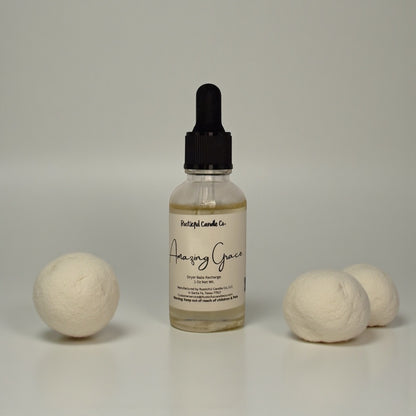 Bottle of 'Amazing Grace' with two spherical laundry balls on a neutral background