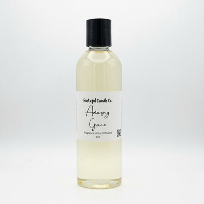 A clear glass bottle of fragrance oil with a black cap and a white label reading 'Relentless Candle Co. Amazing Grace' on a clean white background.