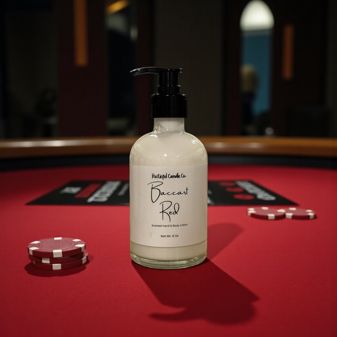 Bottle of Baccarat Red candle on a red felt surface with poker chips.