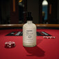 Bottle of Baccarat Red candle on a red felt surface with poker chips.