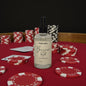 Bottle of Buccanneer Red scented body mist on a poker table with chips and cards.