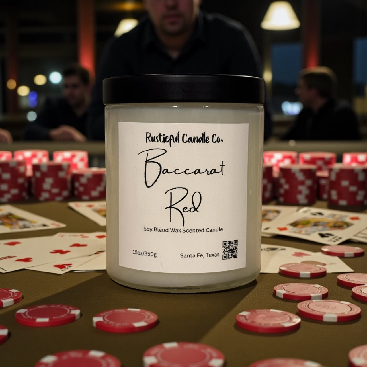 Candle labeled 'Baccarat Red' from Rusticful Candle Co. on a poker table with cards and chips.