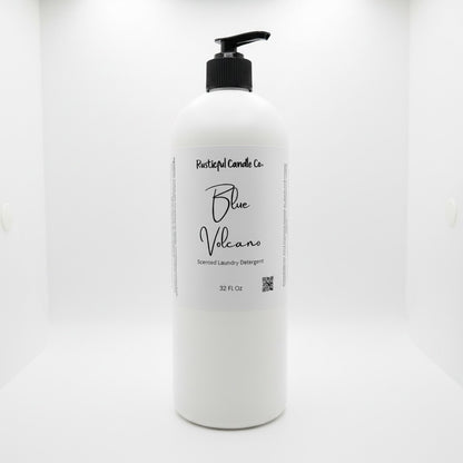 A 32 fl oz white plastic bottle of Rustical Candle Co. Blue Volcano Scented Laundry Detergent with a black pump dispenser and a white label, set against a seamless white background.