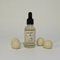 Bottle of Cadillac Cowboy dryer balls refresher with dryer balls on a light gray background