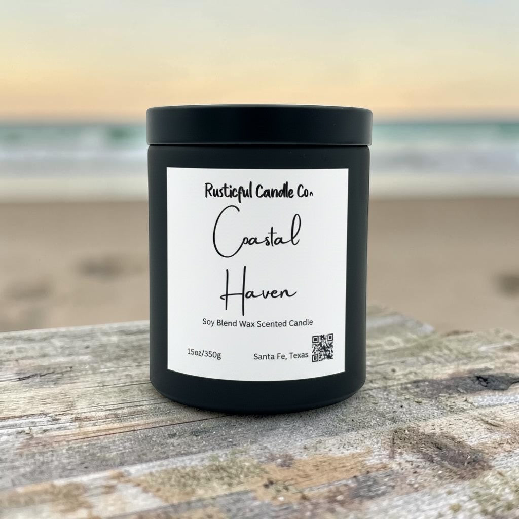 A black jar candle labeled 'Rustical Candle Co. Coastal Haven' sits on a weathered wooden surface with a blurred beach and ocean background.