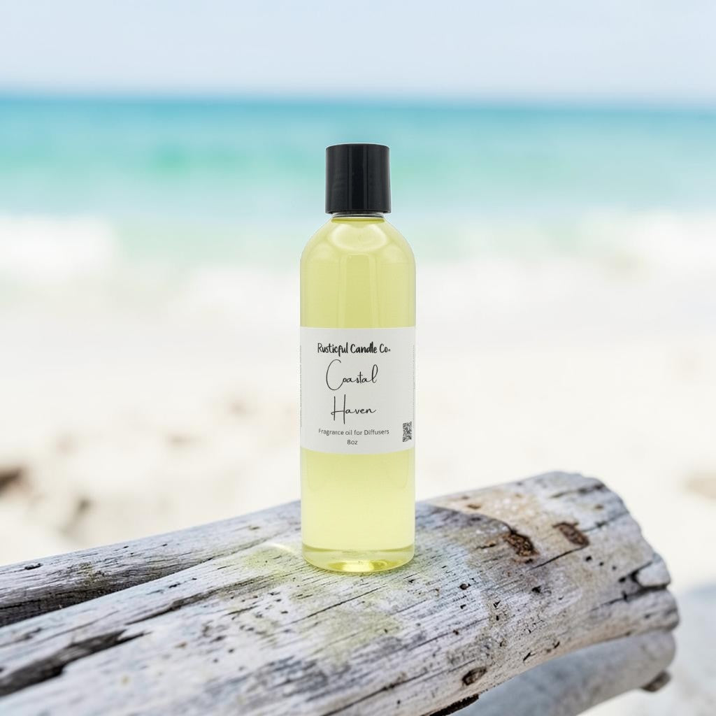A bottle of Natural Candles Co. Candle Hair fragrance oil sits on a weathered piece of driftwood with a blurred beach and ocean background.