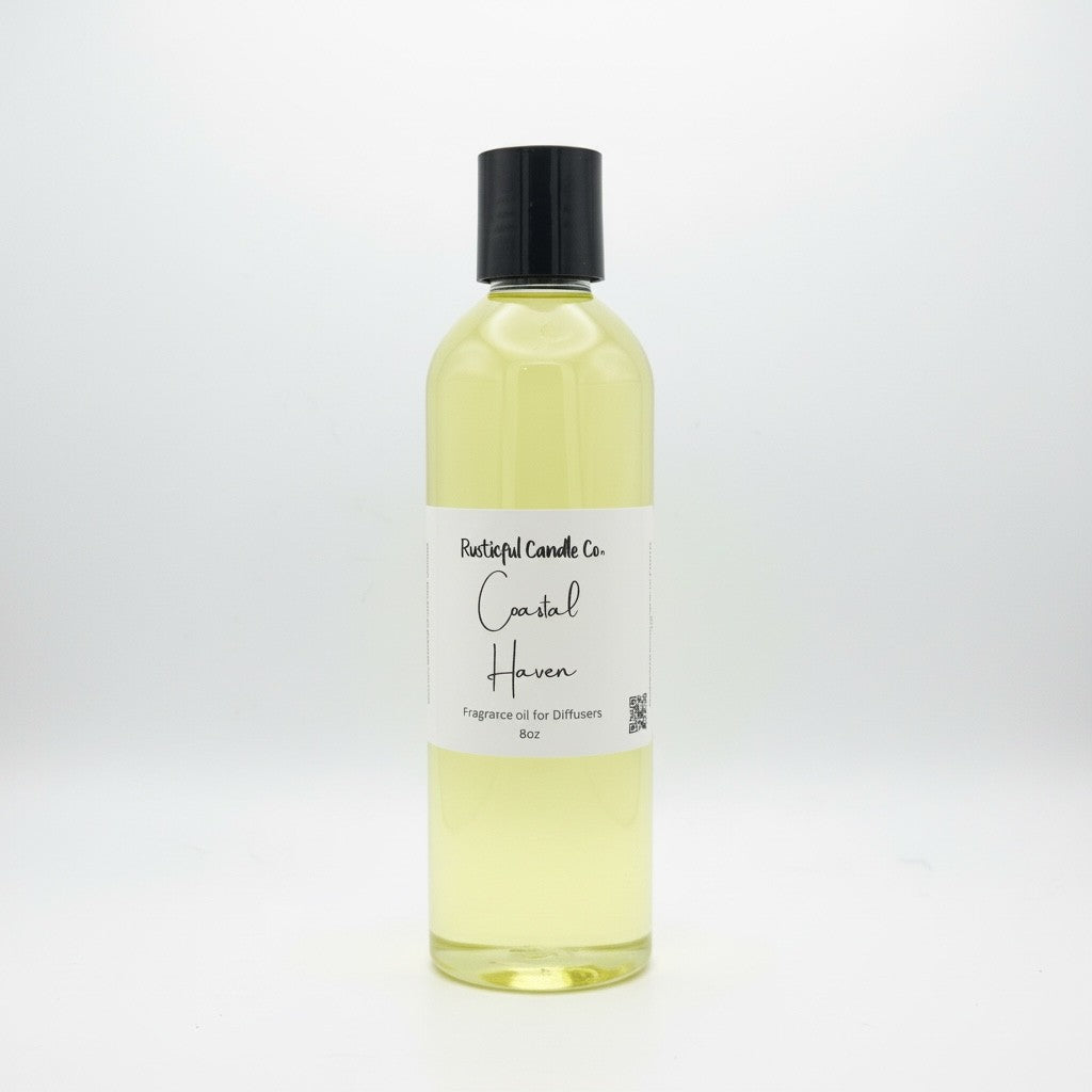 A clear plastic bottle filled with pale yellow fragrance oil, featuring a black screw cap and a white paper label that reads 'Pastel Candle Co. Coastal Haven Fragrance Oil for Diffusers 16oz'.