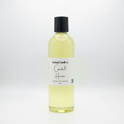 A clear plastic bottle filled with pale yellow fragrance oil, featuring a black screw cap and a white paper label that reads 'Pastel Candle Co. Coastal Haven Fragrance Oil for Diffusers 16oz'.