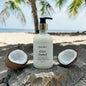Coco Ombré bottle on a rock with coconuts and palm trees in the background