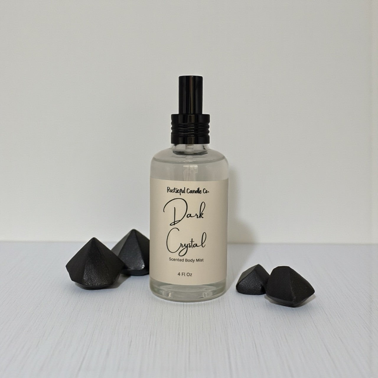 Body mist bottle labeled 'Dark Crystal' with black geometric shapes on a light gray background