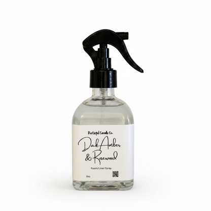 Glass spray bottle with black nozzle labeled 'Dark Amber & Rosewood' on a white background