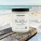 Candle labeled 'Flora de Brazil' from Rusticful Candle Co. on a beach.