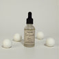Bottle of Fresh Lavender Linen diffuser with cotton balls on a light gray background
