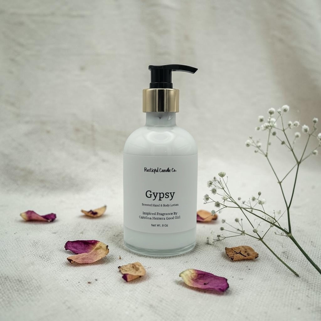 Hand lotion bottle labeled 'Gypsy' with dried flowers and a branch on a textured surface