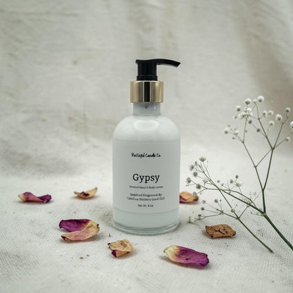 Hand lotion bottle labeled 'Gypsy' with dried flowers and a branch on a textured surface