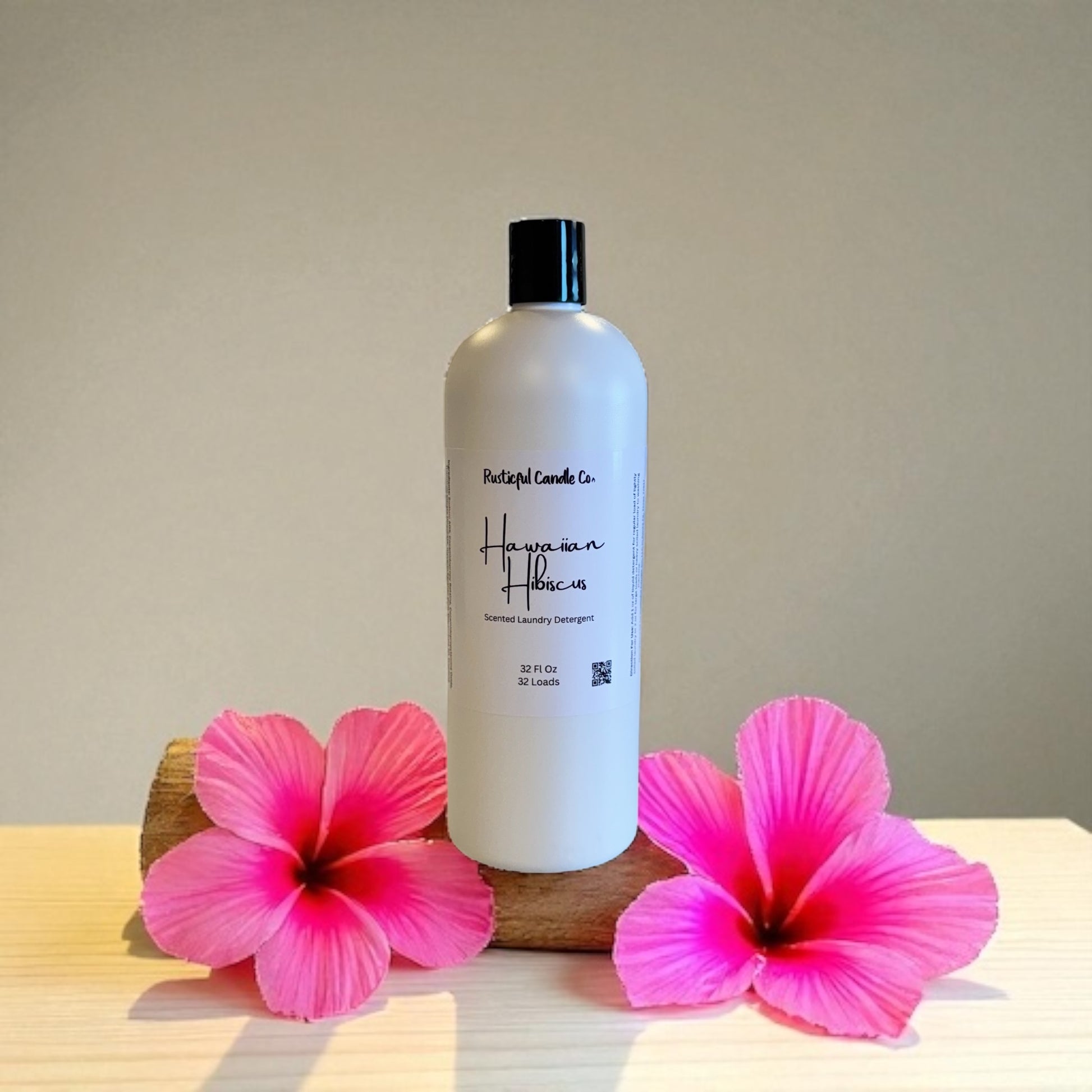 Bottle of Hula Love laundry detergent with pink flowers on a neutral background
