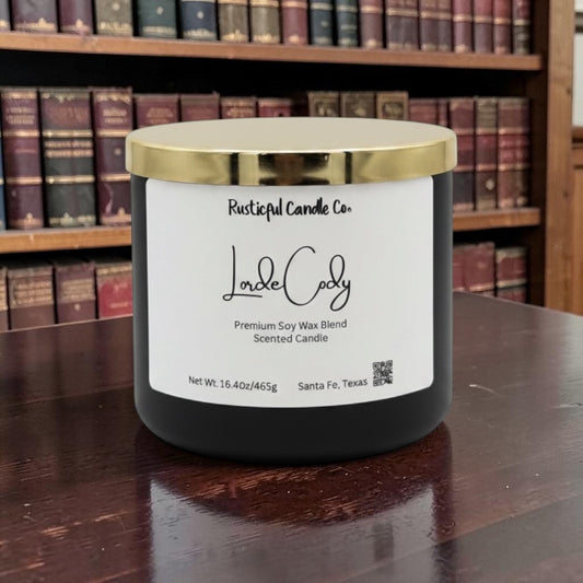 Candle with a gold lid on a wooden surface in front of a bookshelf