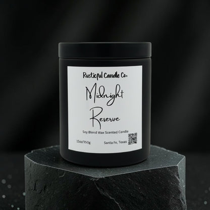 A black jar candle with a white label reading 'Rusticalful Candle Co. Midnight Reserve' sits on a dark stone pedestal against a dark blurred background.