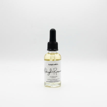 A small clear glass dropper bottle with pale yellow liquid inside, a black dropper cap, and a white label reading 'Paisley Lane Co' and 'Night Romance'.
