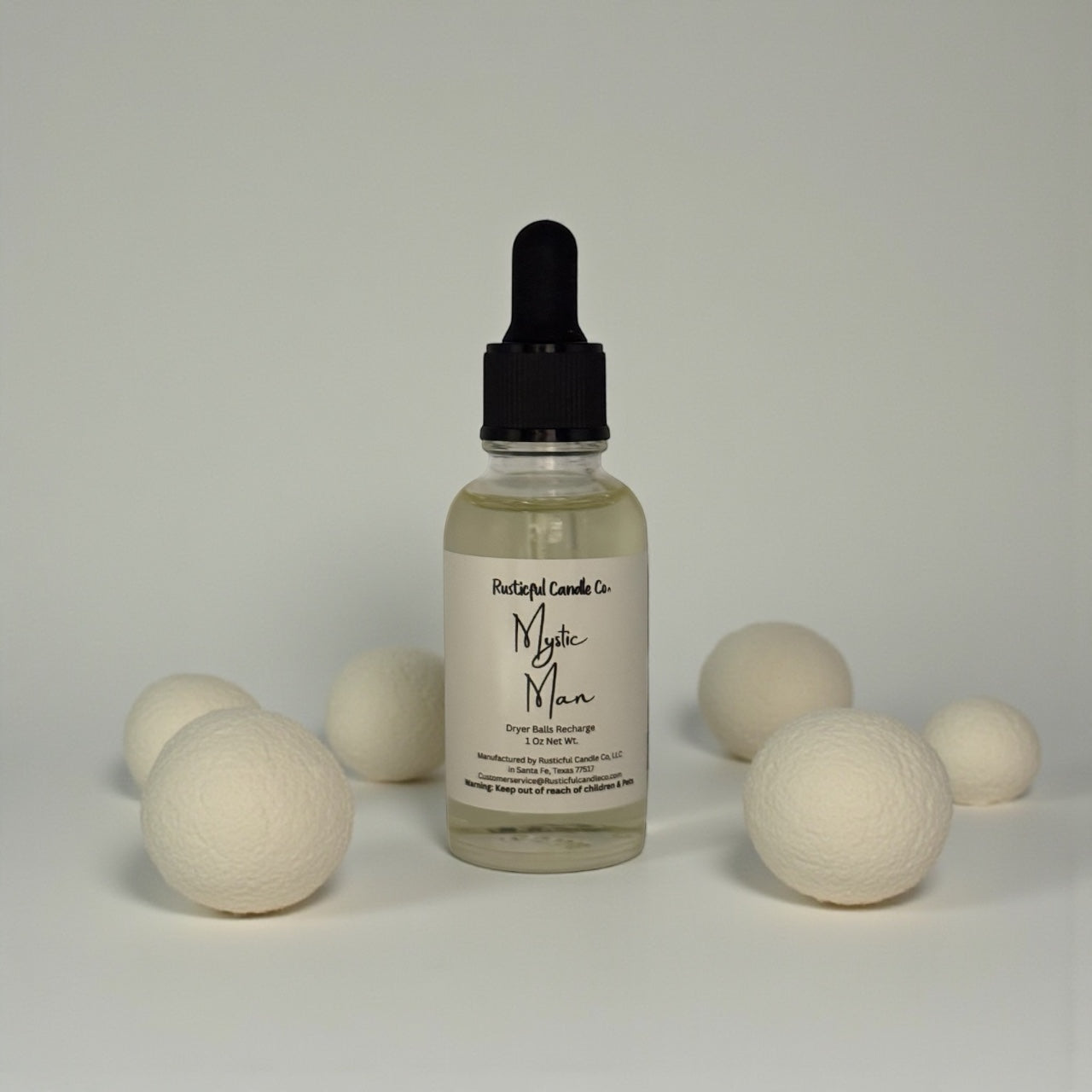 Bottle of Mystic Man product with wooden balls on a neutral background