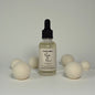 Bottle of Mystic Man product with wooden balls on a neutral background