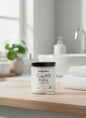Candle labeled 'Oatmeal, Milk & Honey' on a bathroom counter with a blurred background