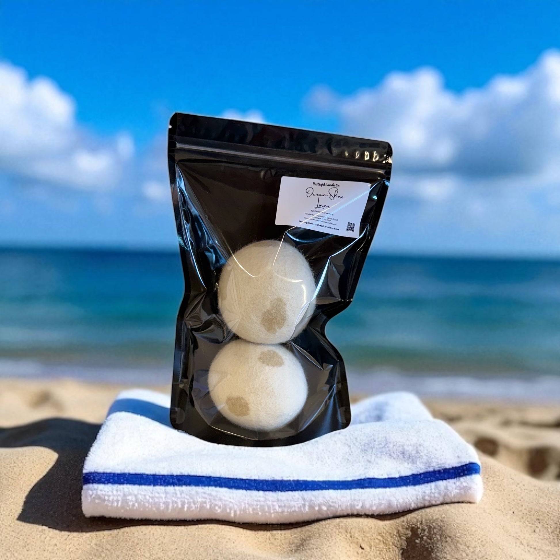 Packaged bath bombs on a towel with a beach background