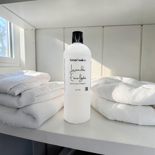 White bottle of laundry detergent with towels on a table in a bright room