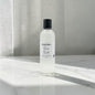 A clear cylindrical bottle of fragrance oil with a black cap and a white label reading 'Pleasant Candle Co. Romeo No.