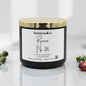 A black jar candle with a shiny gold lid and a white label reading 'Rustical Candle Co. Reverie No.