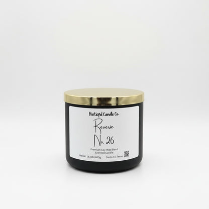 A black jar candle with a shiny gold lid and a white label reading 'Postfulful Candle Co. Reverse No.
