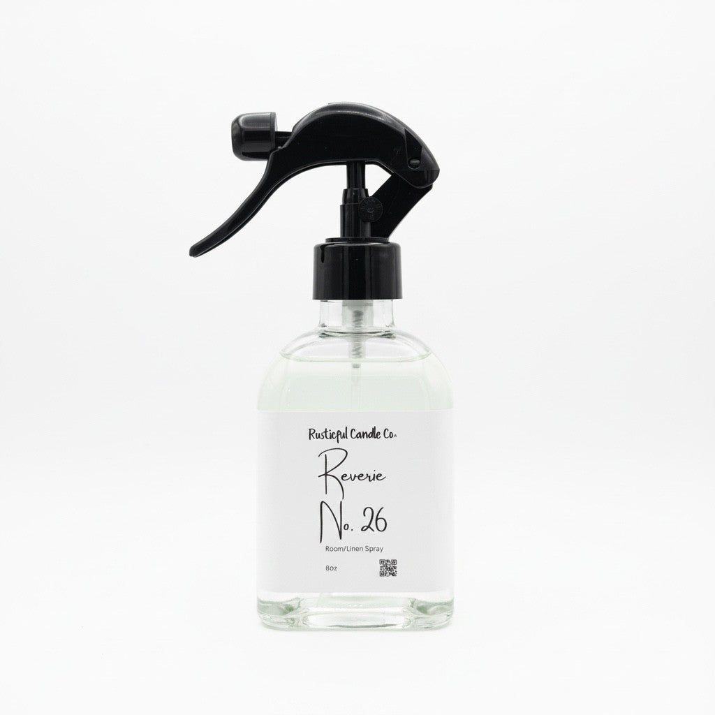 A clear glass spray bottle with a black trigger sprayer and a white label reading 'Pleasant Candle Co. Reverse No.