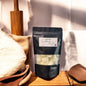 Black packaging of a product with a label on a wooden surface