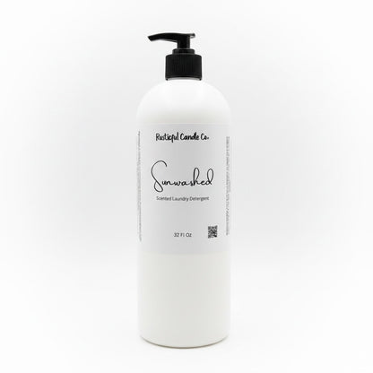 A 32 fl oz white plastic bottle of Rockin' Lullaby Candle Co. 'Sunwashed' Scented Laundry Detergent with a black pump dispenser and a white label, set against a plain white background.