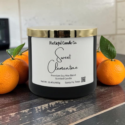 Candle labeled 'Sweet Clementine' from Rusticful Candle Co. with oranges on a wooden surface.
