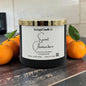 Candle labeled 'Sweet Clementine' from Rusticful Candle Co. with oranges on a wooden surface.
