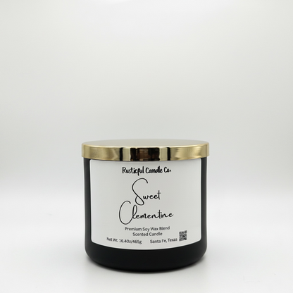 Black candle with a gold lid and white label on a white background