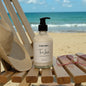Lotion bottle labeled 'Tan Lines' on a beach chair with ocean view