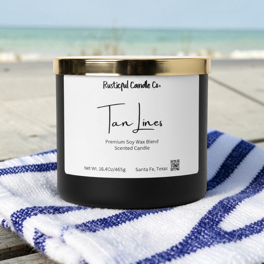 Candle with a label on a striped towel by the beach