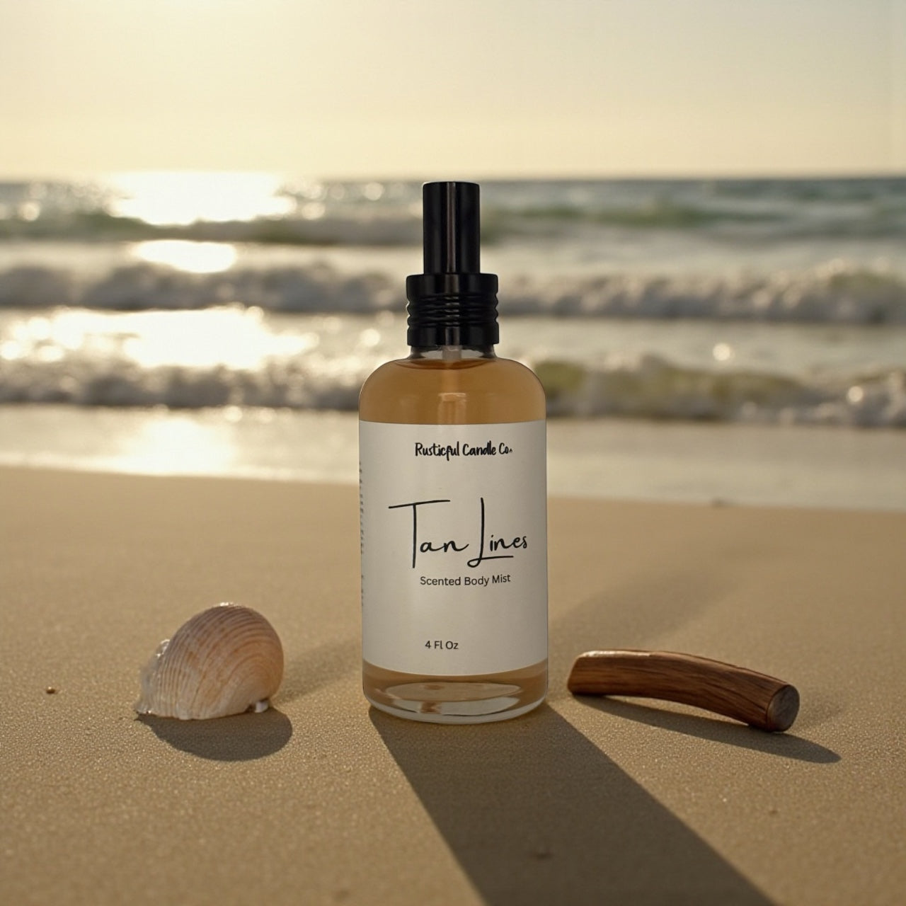 Bottle of 'Tan Lines' scented body mist on a sandy beach with ocean in the background