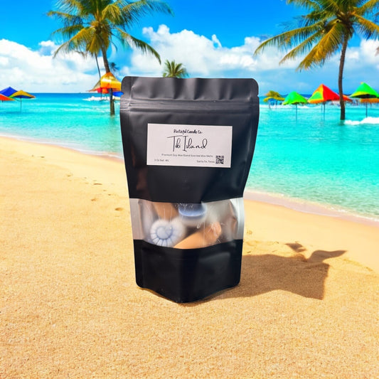 Black package with a label on a sandy beach with palm trees and colorful umbrellas in the background.
