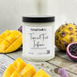 Candle labeled 'Tropical Fruit Infusion' with a pineapple, mango, and blackberry on a wooden surface.