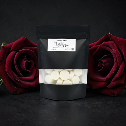 Black pouch with white contents between two red roses on a dark background