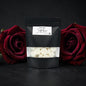 Black pouch with white contents between two red roses on a dark background