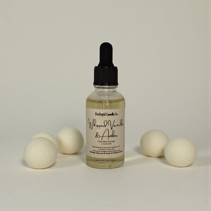 Bottle of 'Whipped Vanilla & Amber' soap bar fragrance with wooden beads on a neutral background