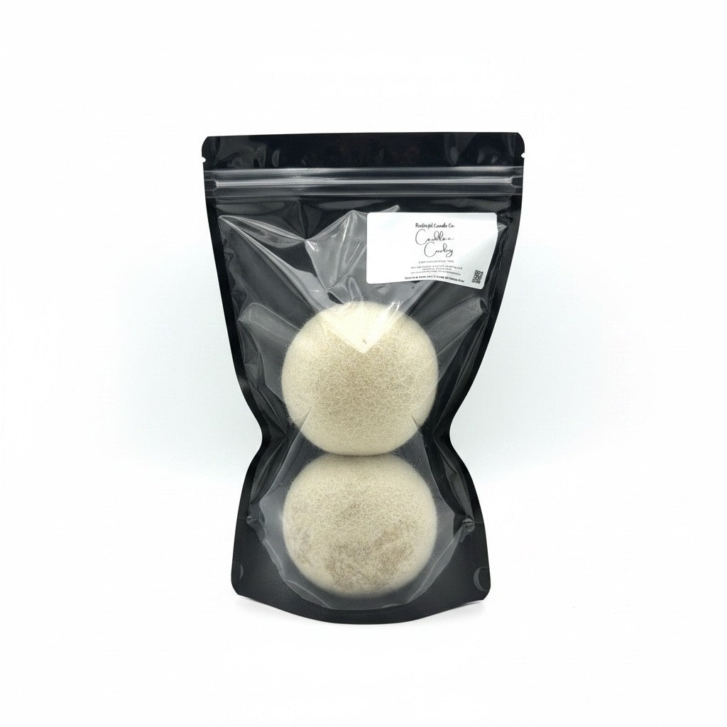 Two round beige bath bomb spheres inside a clear plastic bag with a black resealable pouch and a white label, photographed on a white background.