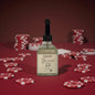 Bottle of Baccarat Red candle on a red background with poker chips.